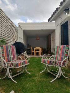 two chairs and a grill in a yard at Casa Olivia Habitación privada in Alta Gracia