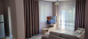 a living room with a couch and a flat screen tv at Orange Apartment in Golem