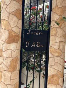 um sinal na lateral de um edifício com flores em Ground floor Jardin D'alba Villamartin em Cabo Roig
