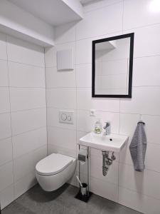 a white bathroom with a toilet and a sink at MY HOME EUROPAALLEE 26 in Villingen-Schwenningen