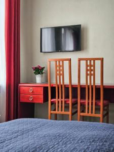 a bedroom with two chairs and a desk with a television at Muzeja apartamenti in Riga