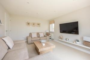 uma sala de estar com um sofá e uma televisão de ecrã plano em Luxury Detached Home em Edimburgo