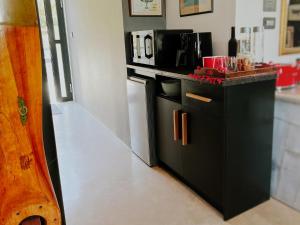 a kitchen with a black counter and a microwave at Chez ArtéKatz in Cape Town