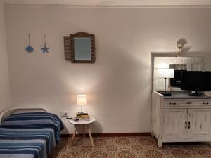 a bedroom with a bed and a tv and a mirror at Casa vacanze Marinella in Santo Stefano al Mare