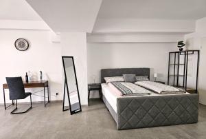 Un dormitorio con una cama, un escritorio y un espejo. en MY HOME EUROPAALLEE 26, en Villingen-Schwenningen 19 fotos más
