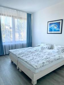 a bedroom with a white bed with a large window at Stay Westend in Wetzlar