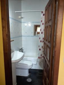 a bathroom with a white toilet and a sink at OSO4 in Pola de Somiedo