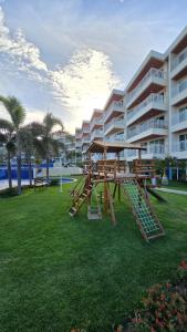 una mesa de picnic en un parque frente a un edificio en Apartamento Confortável - Porto das Dunas - Perto do Beach Park, en Aquiraz