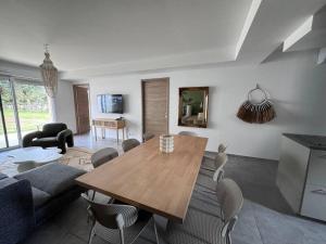 a living room with a wooden table and chairs at Maison Joepolly corsica in Bonifacio