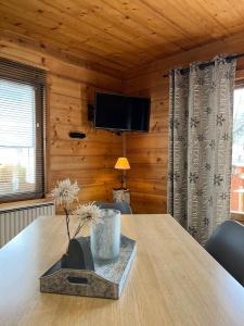 a wooden room with a table and a tv at LAPRESKI, Appartement 4 étoiles, atmosphère chaleureuse entre Annecy et Aravis in Thônes