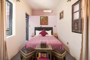 um quarto com uma cama com 2 cadeiras e uma mesa em RIAD MAMAHOUSE em Marrakech