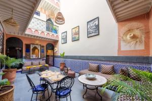 a patio with a couch and tables and chairs at RIAD MAMAHOUSE in Marrakech