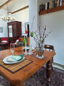 una mesa de madera con un jarrón de bolas verdes. en Studio Nałęczów en Nałęczów