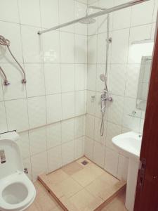 ein Bad mit einer Dusche, einem WC und einem Waschbecken in der Unterkunft Simon's Place in Kigali