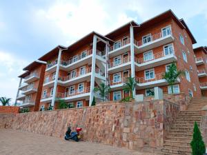 ein großes Apartmenthaus vor einer Backsteinmauer in der Unterkunft Simon's Place in Kigali