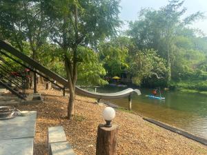 een park met een glijbaan naast een rivier bij ชลลดา ริเวอร์ โฮมสเตย์ แก่งกระจาน in Ban Wang Malako