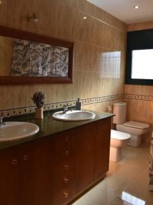 een badkamer met 2 wastafels en een toilet bij Cal Nene - plamun es in Begur