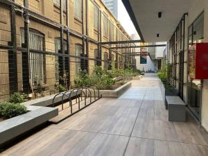 un couloir vide d'un bâtiment avec bancs et plantes dans l'établissement Departamento ñuñoa, à Santiago