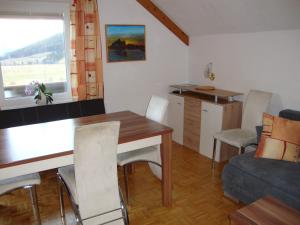 kuchnia i salon ze stołem i kanapą w obiekcie Apartment Haus Dengg w mieście Mauterndorf