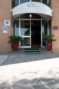 an entrance to a hotel with two potted plants at Art Hotel in Mirano