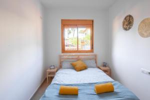 a small bedroom with a bed and a window at Namawa Surfhouse in Chiclana de la Frontera