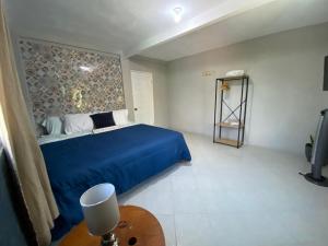 een slaapkamer met een blauw bed en een tafel bij Habitación cerca del aeropuerto #2 in La Paz