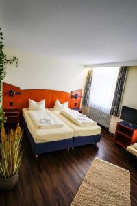 ein Schlafzimmer mit einem großen Bett in einem Zimmer in der Unterkunft Hotel Stadt Daun in Daun