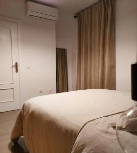 - une chambre avec un lit blanc et une fenêtre dans l'établissement Piso en centro San Juan Alicante, à San Juan de Alicante