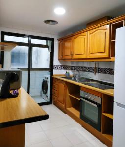 - une cuisine avec des placards en bois et un comptoir dans l'établissement Piso en centro San Juan Alicante, à San Juan de Alicante