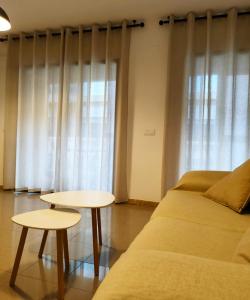 - un salon avec un canapé et deux tables dans l'établissement Piso en centro San Juan Alicante, à San Juan de Alicante