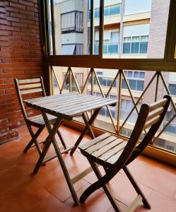 une table de pique-nique et une chaise en face d'une fenêtre dans l'établissement Piso en centro San Juan Alicante, à San Juan de Alicante