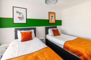 two beds in a room with green and white at Ark on the Hill in Chatham