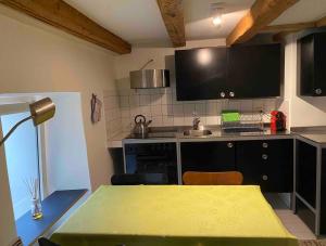 una cucina con tavolo e piano di lavoro giallo di Le Quartier 10 a Saint-Ursanne