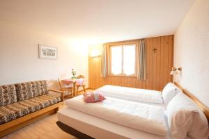 a hotel room with a bed and a couch at Hotel Kurhaus Heiligkreuz in Heiligkreuz