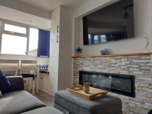 a living room with a couch and a fireplace at 'New Memories' Dog Friendly Holiday Chalet in Bridlington