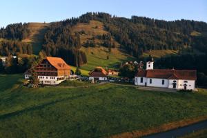 een klein dorpje met een kerk op een groene heuvel bij Hotel Kurhaus Heiligkreuz in Heiligkreuz
