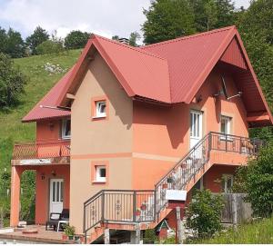 a large house with a red roof at CAMPING ZELENI GAJ (GREEN FOREST) in Pluzine