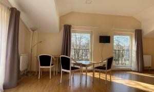 a dining room with a table and chairs and a window at Parko Studija in Birštonas