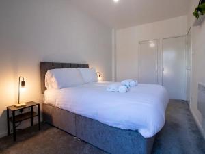 sypialnia z dużym białym łóżkiem z dwoma pluszakami w obiekcie Pass the Keys Modern Minimalistic Apartment in City centre w mieście Newcastle upon Tyne