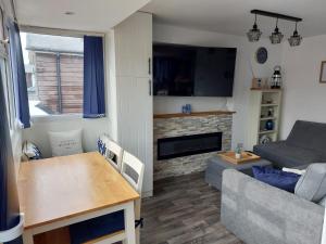a living room with a couch and a table at 'New Memories' Dog Friendly Holiday Chalet in Bridlington