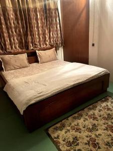 uma cama com uma cabeceira de madeira e um tapete em The First House - 2 BHK in Main Gangtok em Gangtok