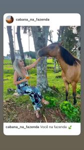 Una donna seduta per terra accanto a un cavallo di Cabana na Fazenda a São Francisco de Paula