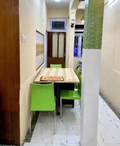 uma sala de jantar com uma mesa e cadeiras verdes em The First House - 2 BHK in Main Gangtok em Gangtok