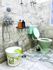 y baño con aseo verde y ducha. en The First House - 2 BHK in Main Gangtok en Gangtok
