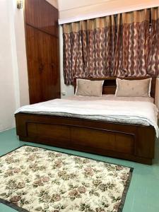 Una cama con marco de madera y una alfombra en un dormitorio en The First House - 2 BHK in Main Gangtok en Gangtok
