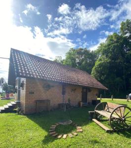 a small brick building with a wheel in front of it at Cabana na Fazenda in São Francisco de Paula