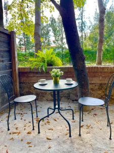 einen Tisch, zwei Stühle und einen Baum in der Unterkunft ValQuirico Loft 4 in Santeagueda