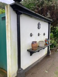 a smallshed with a shelf on the side of it at Quinta de Santana - Queimadas in Furnas