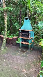 una estufa azul sentada en medio de un bosque en Quinta de Santana - Queimadas, en Furnas