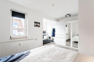 Dormitorio blanco con espejo y cama en Ferienwohnung Relax Happy Schönberger Strand, en Schönberger Strand